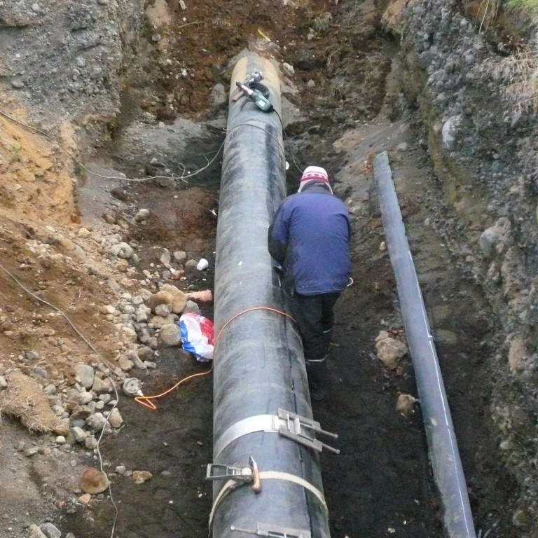 Unnið að því að sjóða nýja plastkápu utan um ný einangrað stálrör á stofnæð til Húsavíkur